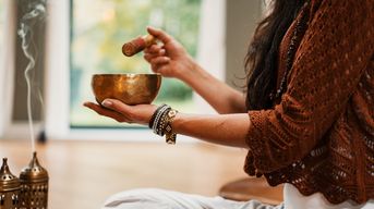 A woman holding a singing bowl. Photo credit: https://unsplash.com/photos/VsI_74zRzAo 