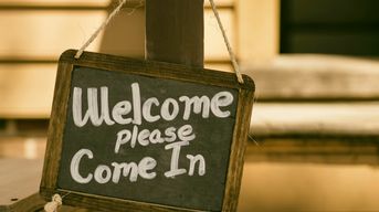 A chalk sign that says "Welcome; Please Come In" / Photo Credit: Unsplash 